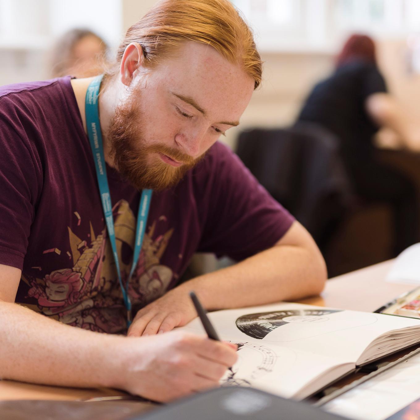 An illustration student works in his sketchbook
