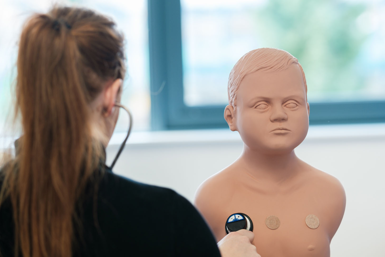 Students monitoring healthcare dummy equipment